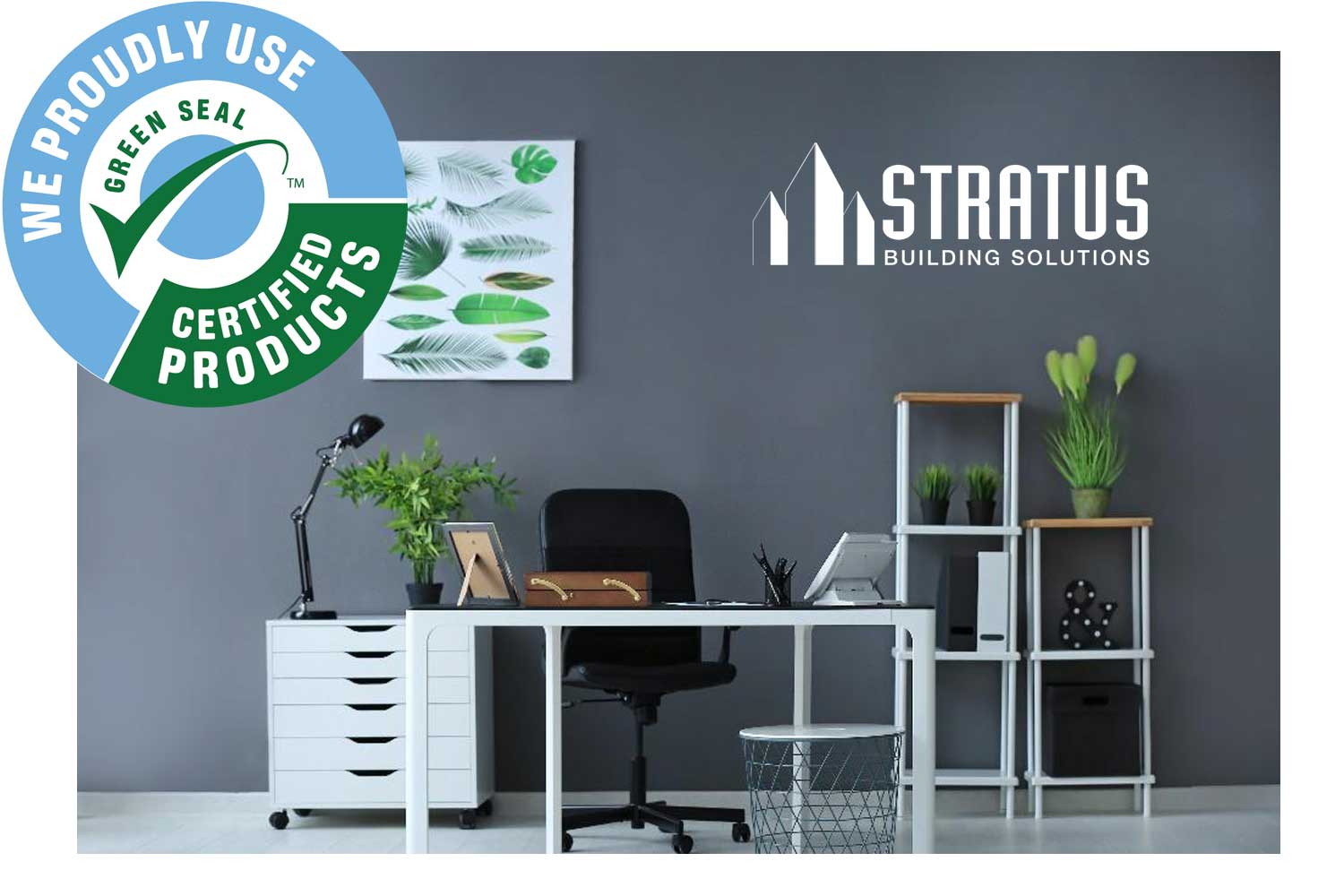 A picture of an office space with white desks, a black rolling chair, and several plants.