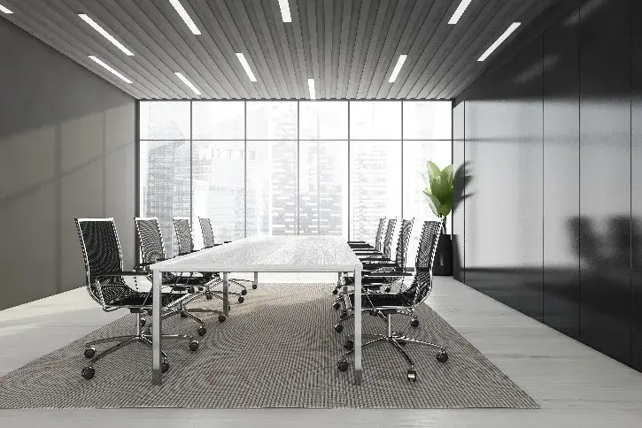 A photo of a conference room with large windows, a long table, and several rolling chairs.
